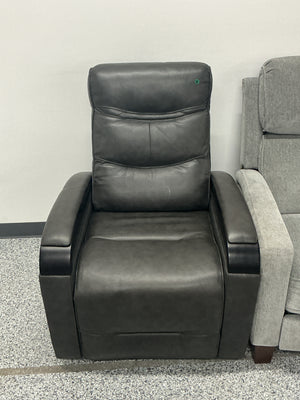 Black leather recliner chair with padded backrest, next to a gray upholstered chair.